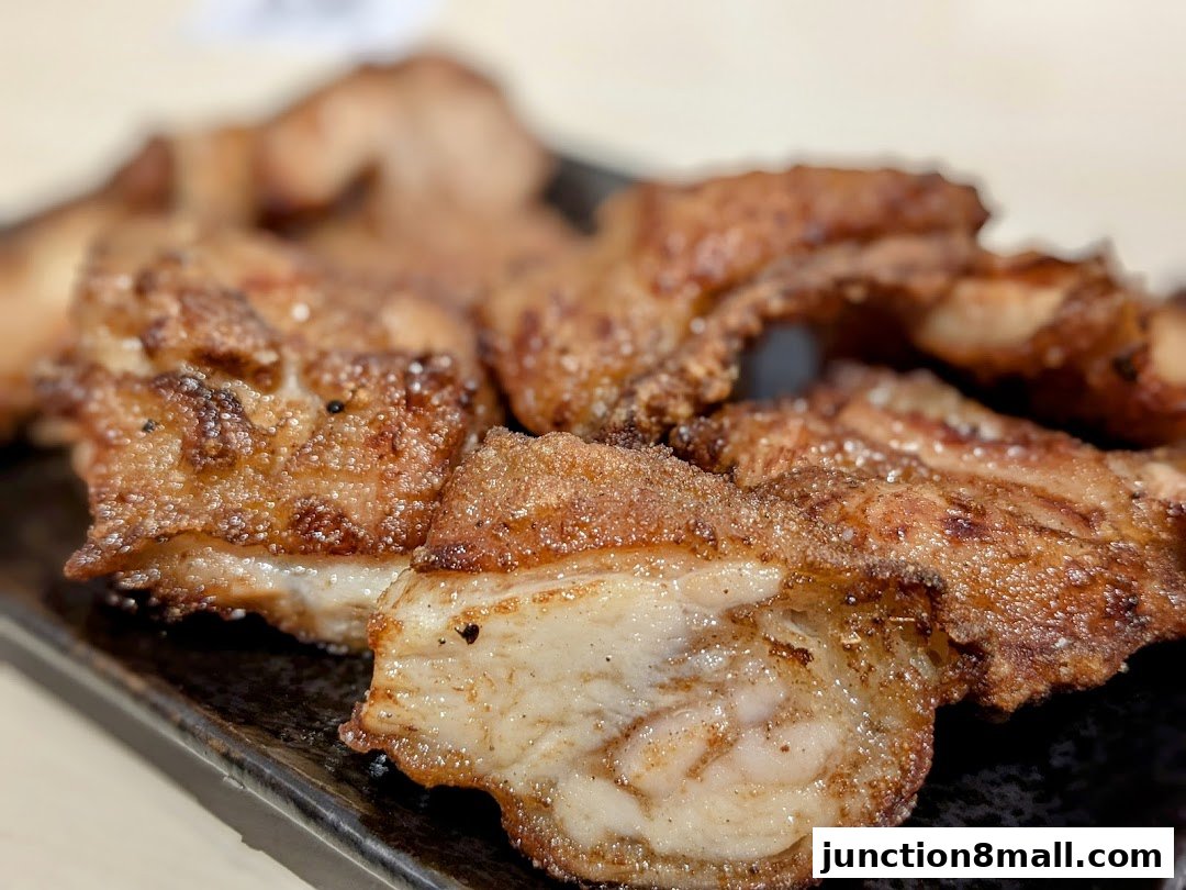 Close-up of crispy, golden-brown fried chicken pieces on a dark plate.