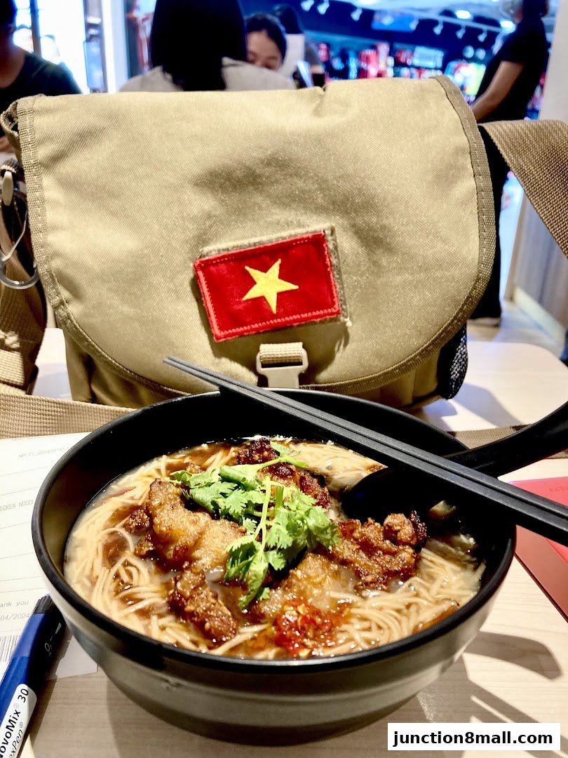 A bowl of Taiwanese noodles with meat and cilantro, next to a bag with a Vietnamese flag.
