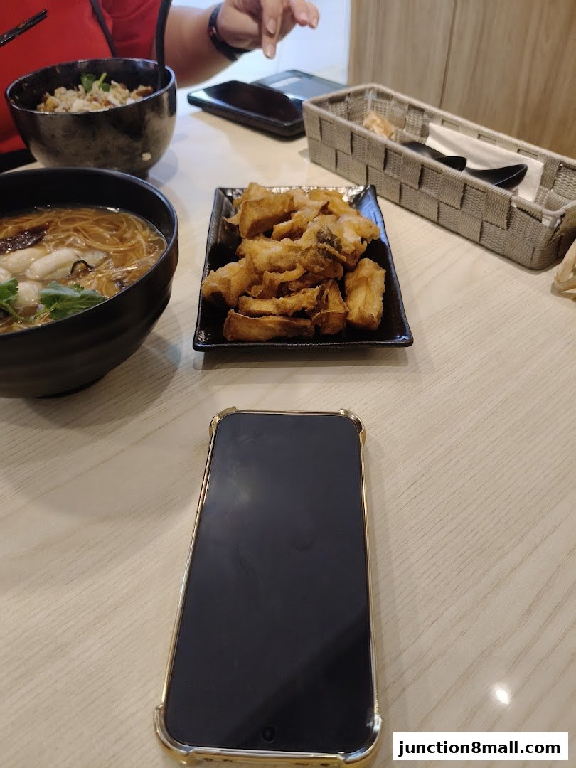 A table setting with Taiwanese food, including noodles, rice, and fried items.