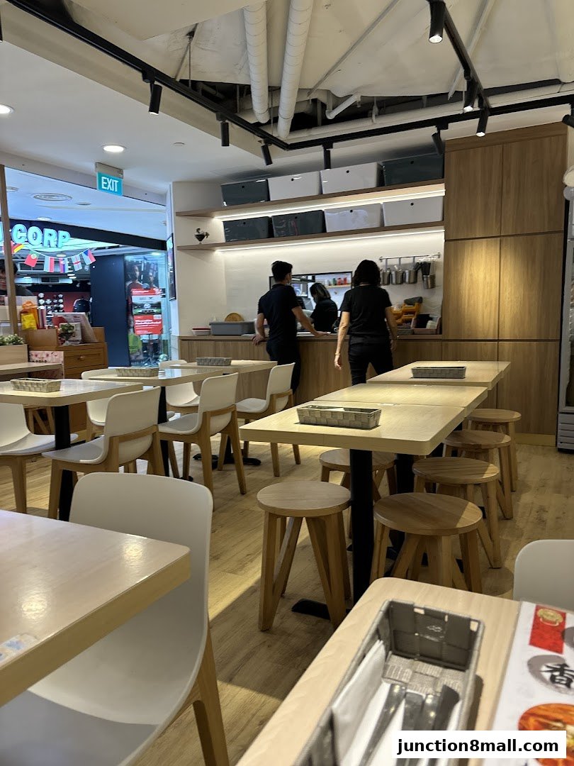 Interior of a modern Taiwanese restaurant with tables, chairs, and staff at the counter.