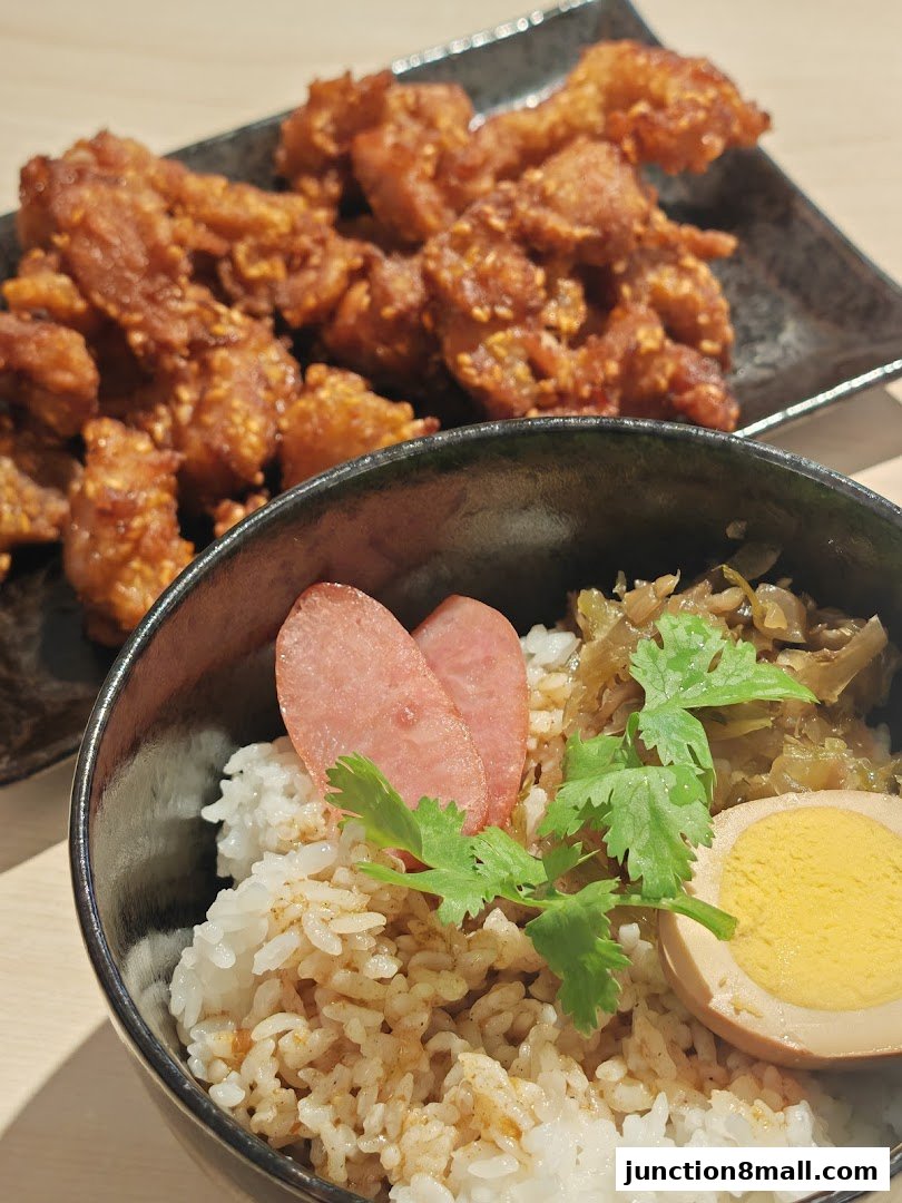 A close-up of Taiwanese fried chicken and a rice bowl with egg and pickled vegetables.