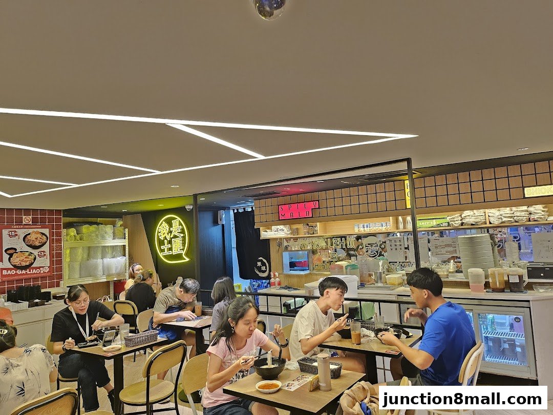 Diners enjoy meals inside a brightly lit TamJai SamGor Mixian restaurant.