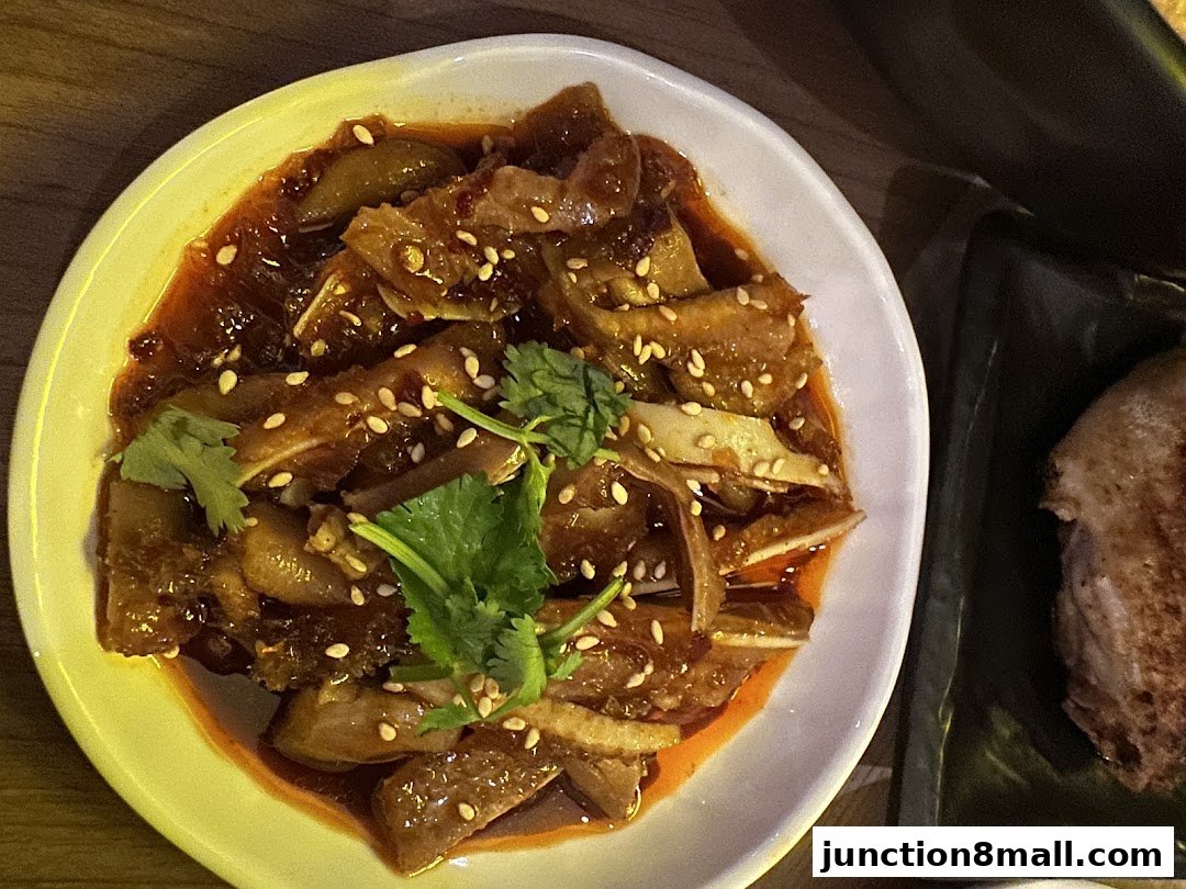 A close-up of a delicious dish with sliced meat, chili oil, and sesame seeds.