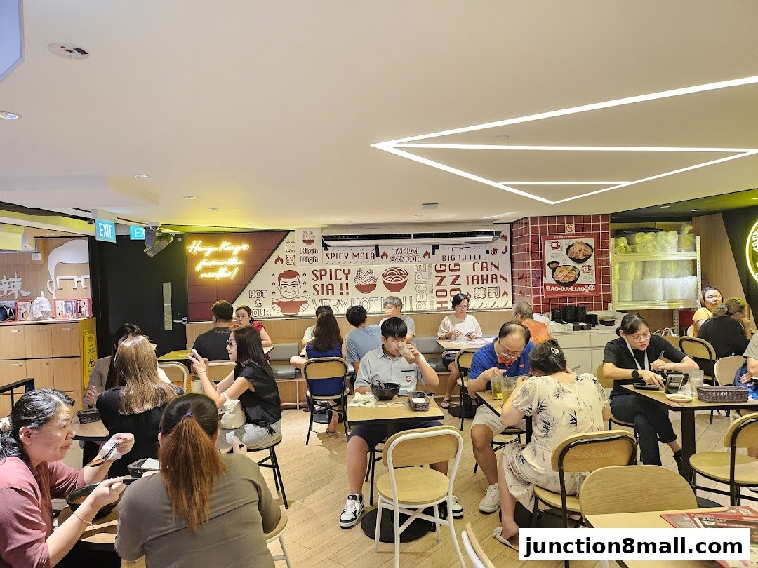 Diners enjoying meals at TamJai SamGor Mixian Junction 8, a busy restaurant interior.