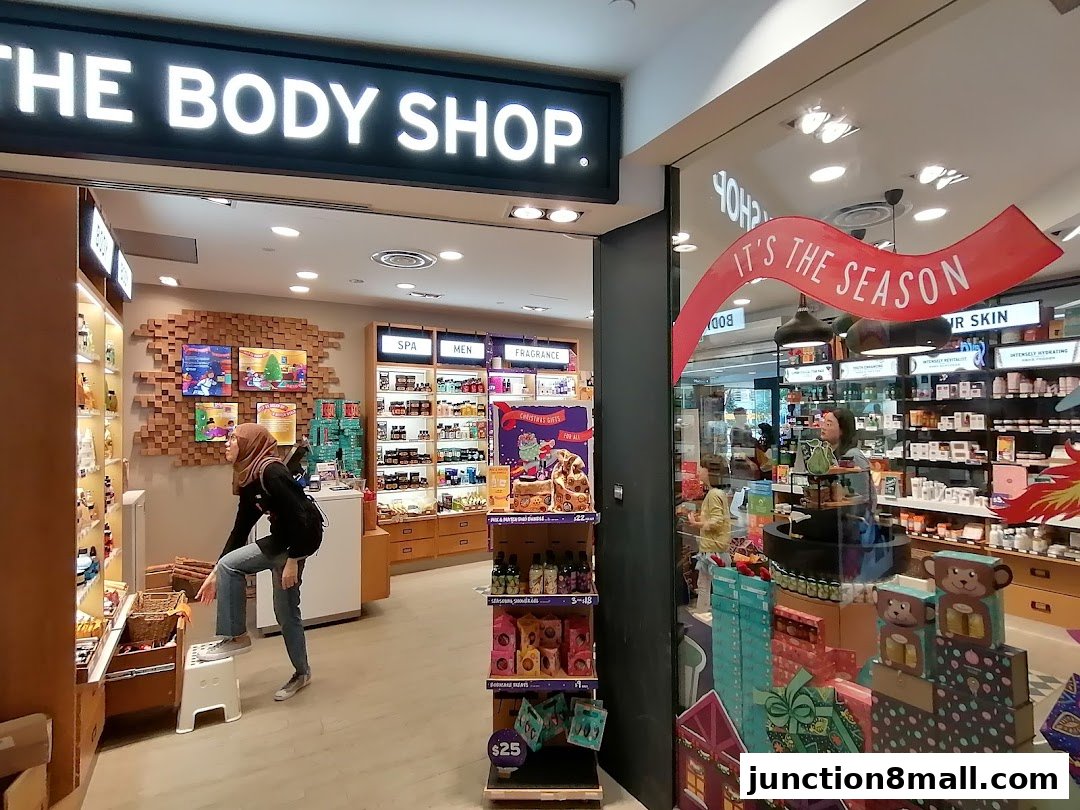 The Body Shop storefront with products displayed inside and a festive holiday decoration.