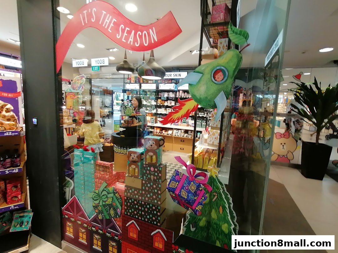 The Body Shop storefront decorated with festive holiday displays and products.