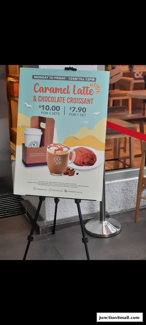 A promotional sign for The Coffee Bean and Tea Leaf featuring a caramel latte and chocolate croissant.