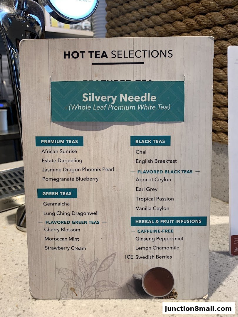 A menu board displaying various hot tea selections, including premium, green, black, and herbal teas.