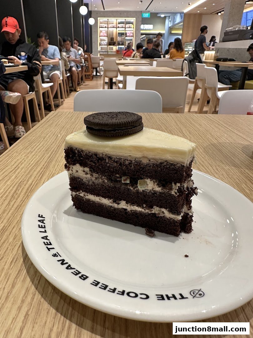 A slice of chocolate cake with an Oreo on top, served on a plate from The Coffee Bean & Tea Leaf.