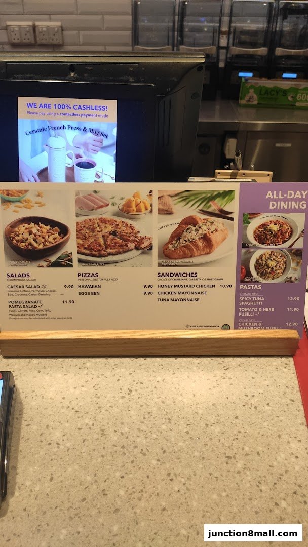 A menu board displaying salads, pizzas, sandwiches, and pastas with prices.