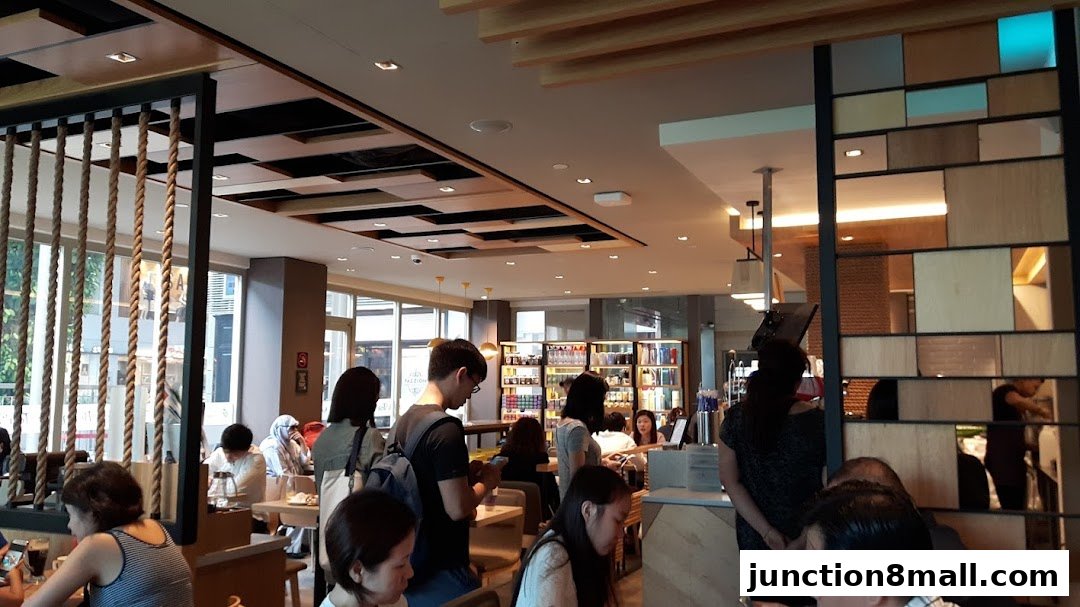 Interior view of The Coffee Bean and Tea Leaf with customers seated and staff behind the counter.