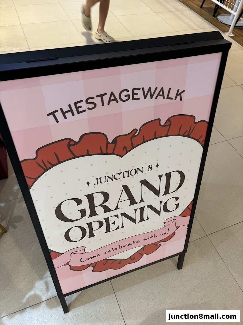 A-frame sign announcing the grand opening of The Stage Walk at Junction 8.