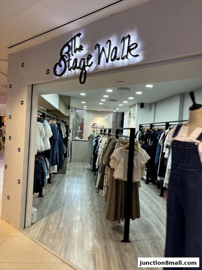 The entrance to 'The Stage Walk' clothing store, showcasing racks of stylish apparel.