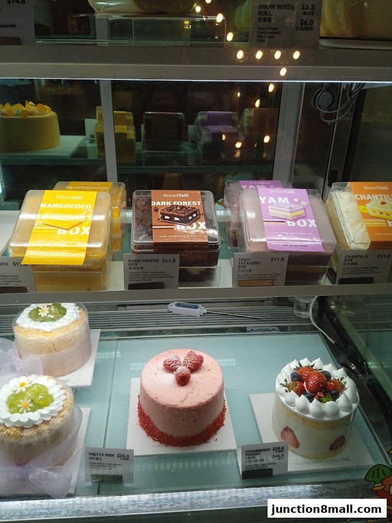 A display case filled with various cakes and dessert boxes from BreadTalk.