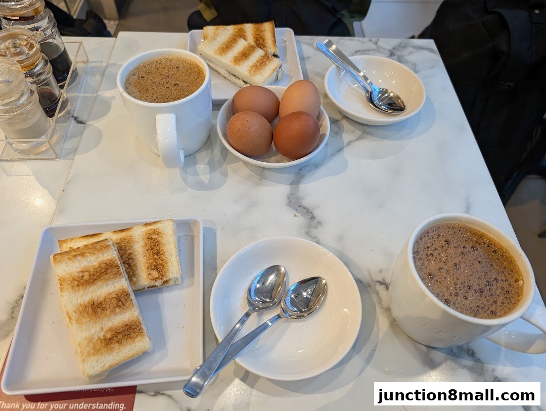 A table setting with two cups of coffee, toast, and boiled eggs.
