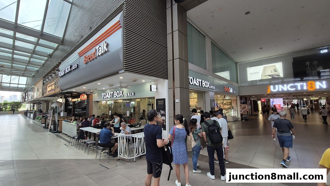 A busy Toast Box shop with customers dining and queuing outside.