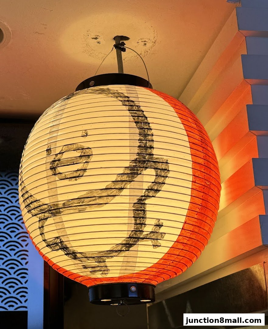 A Japanese lantern with calligraphy hangs from the ceiling, illuminated by warm light.