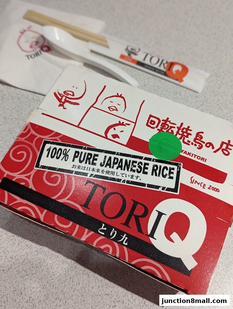 A close-up of a Tori-Q takeout box with chopsticks and a napkin.