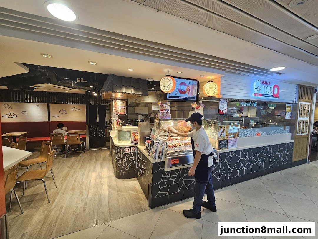 A Tori-Q shop with a staff member serving customers and various skewers displayed.