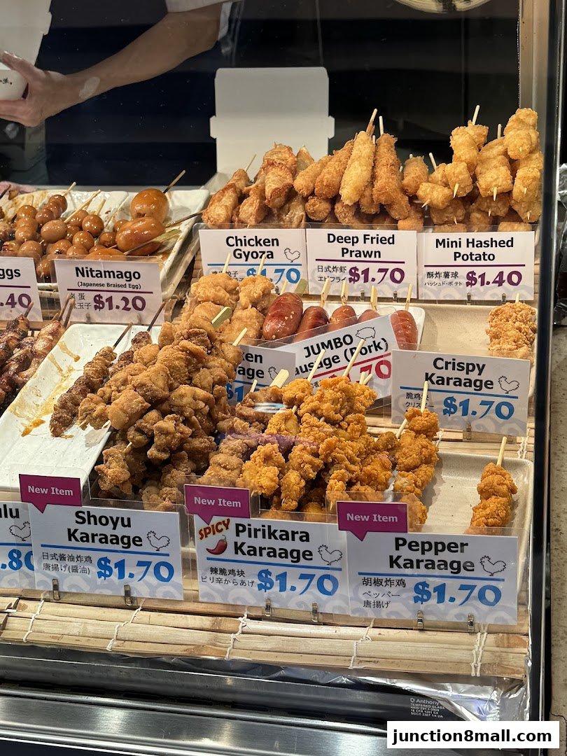 A display of various fried skewers and Japanese dishes with price labels.