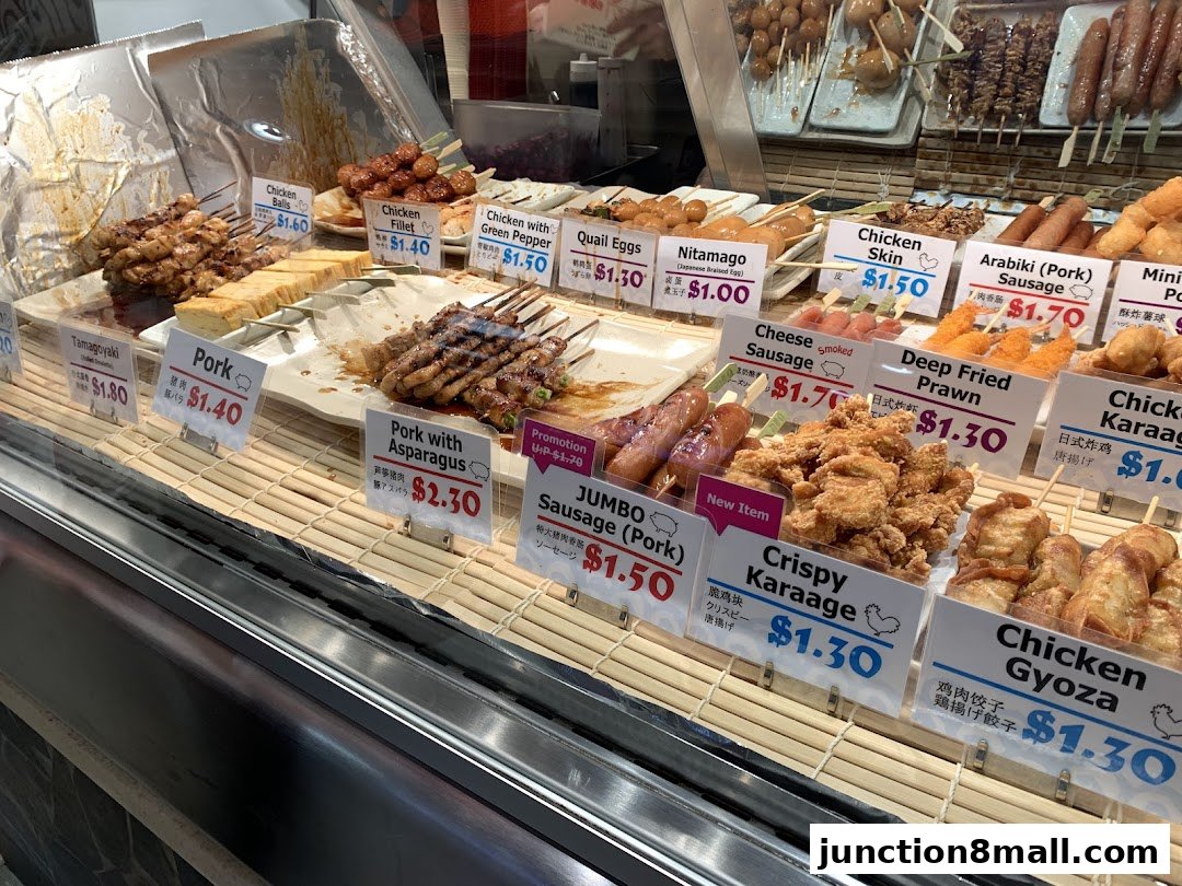 A display of various Japanese skewers and fried items with prices.