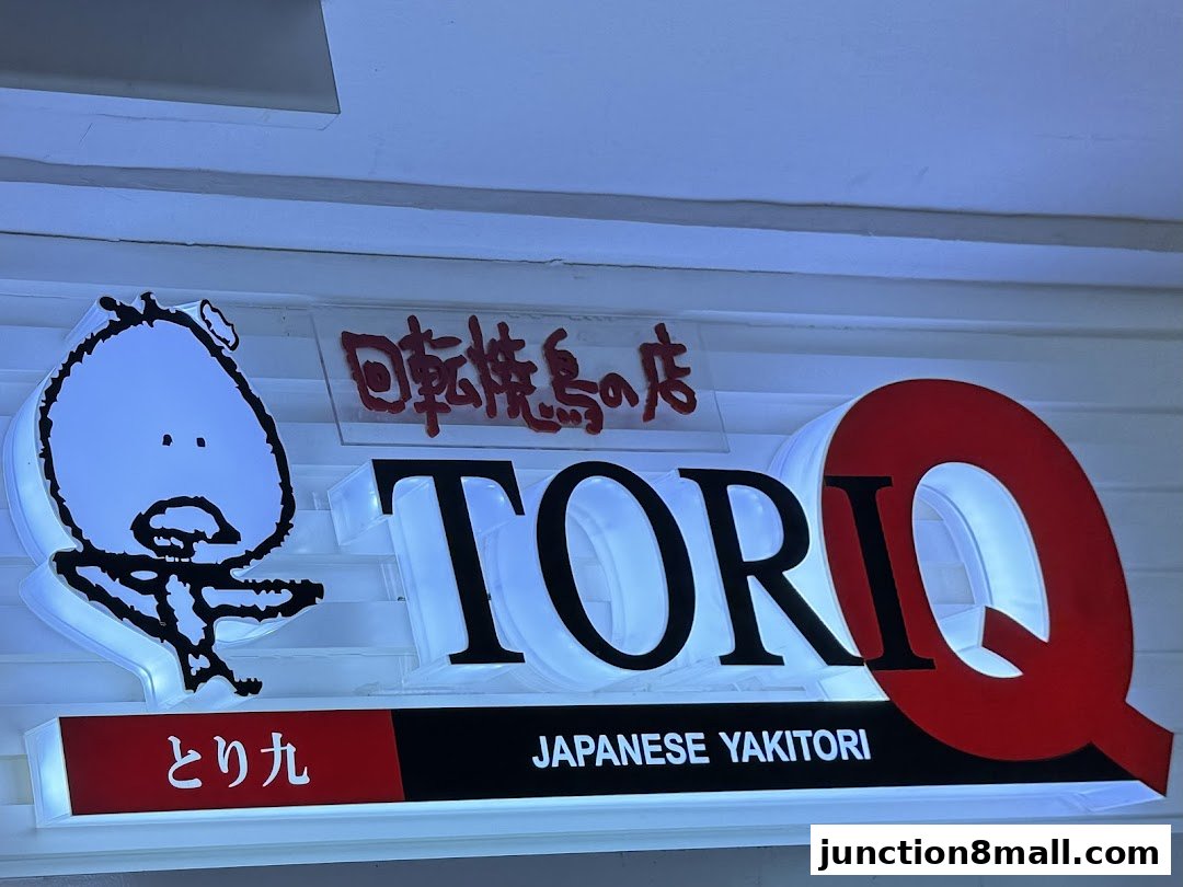 The Tori-Q Junction 8 shop sign features illuminated letters and a cartoon character.