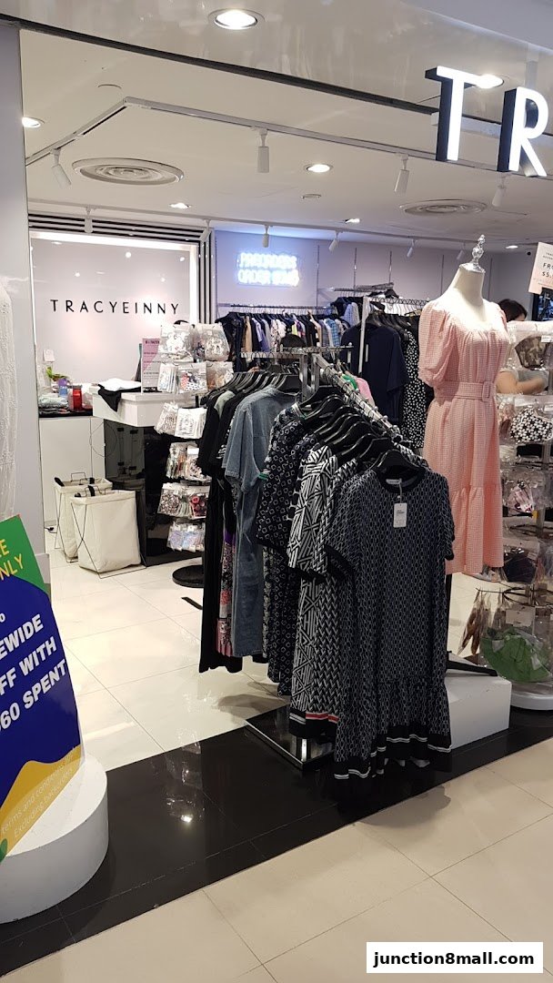 A clothing store interior with racks of dresses and accessories, and a mannequin.