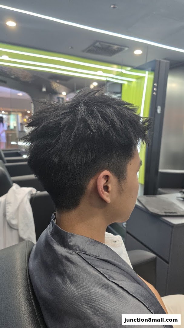A person's head and shoulders are shown from the side, with a stylish haircut.