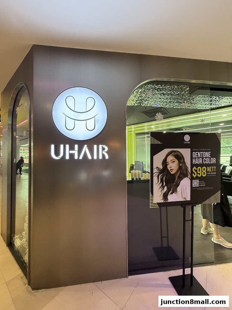 The exterior of U Hair Bishan salon, featuring its logo and a promotional poster for hair color.