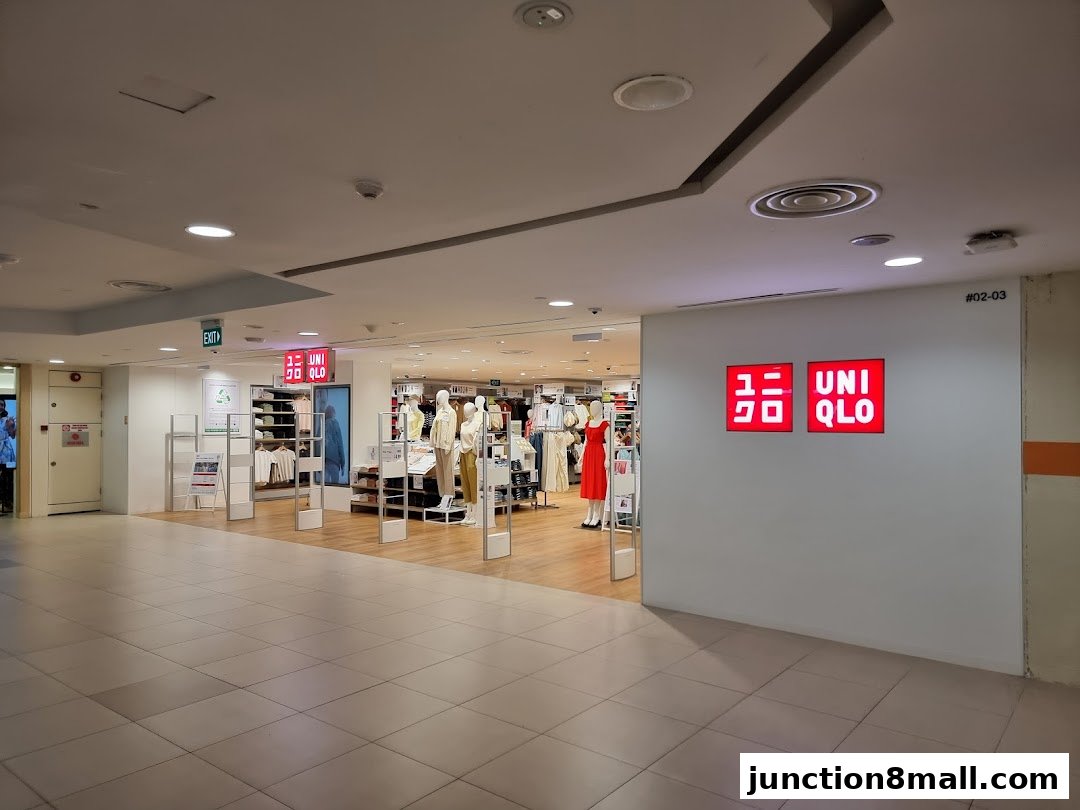 The entrance to a brightly lit Uniqlo store with mannequins displaying clothing.