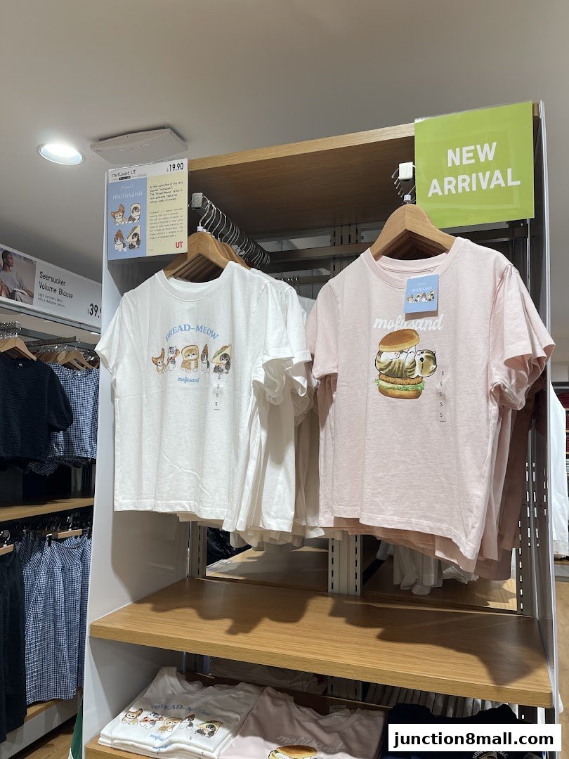 UNIQLO store interior displaying new arrival graphic t-shirts with cute cat designs.