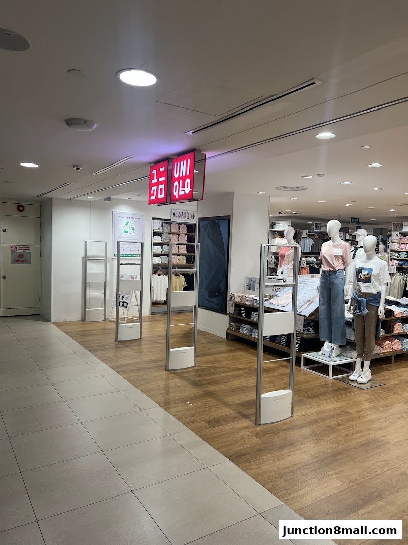 The entrance to a UNIQLO store with mannequins displaying clothing and the UNIQLO logo.