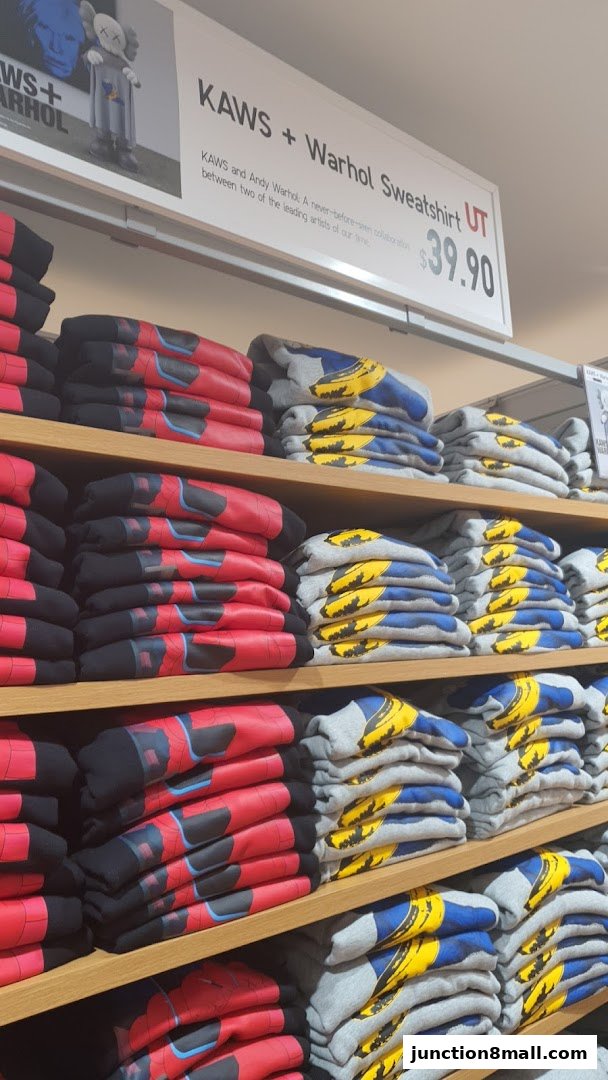 Shelves stacked with folded sweatshirts featuring KAWS + Warhol designs.