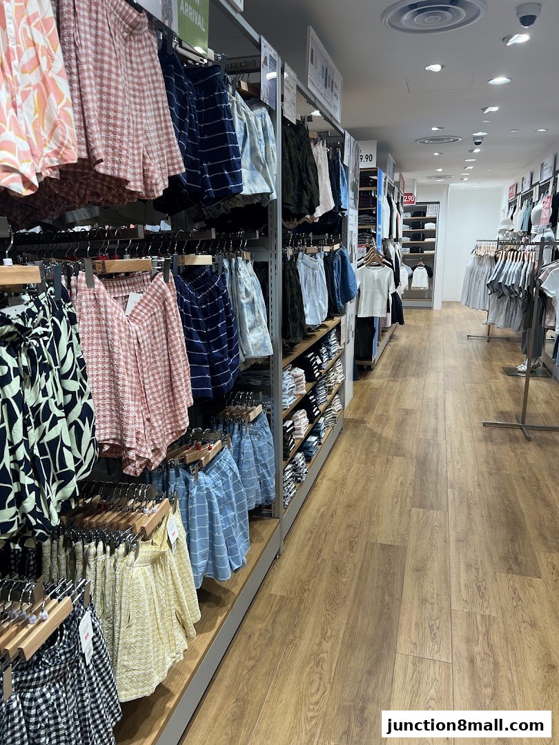 Interior view of a UNIQLO store showcasing a variety of shorts and apparel on display racks.