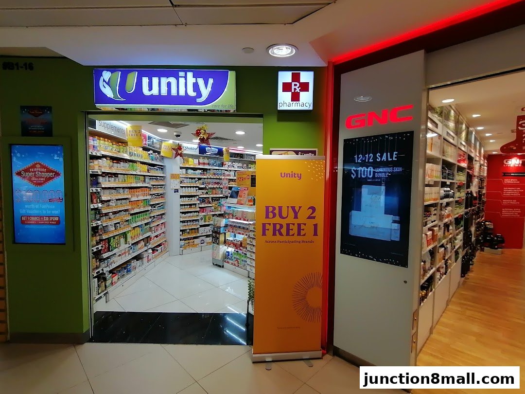 The entrance to Unity pharmacy and GNC stores, showcasing promotions and product displays.
