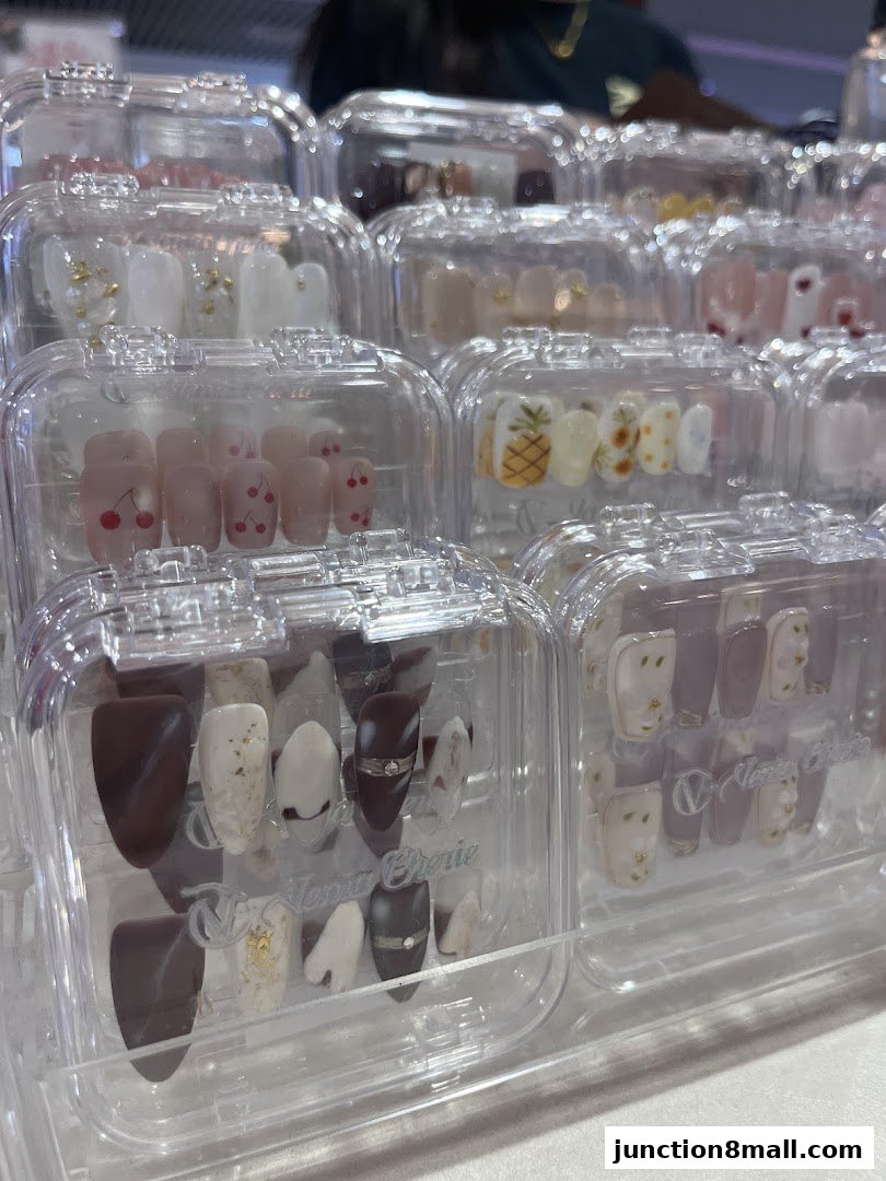 A display of various pre-designed artificial nails in clear cases.