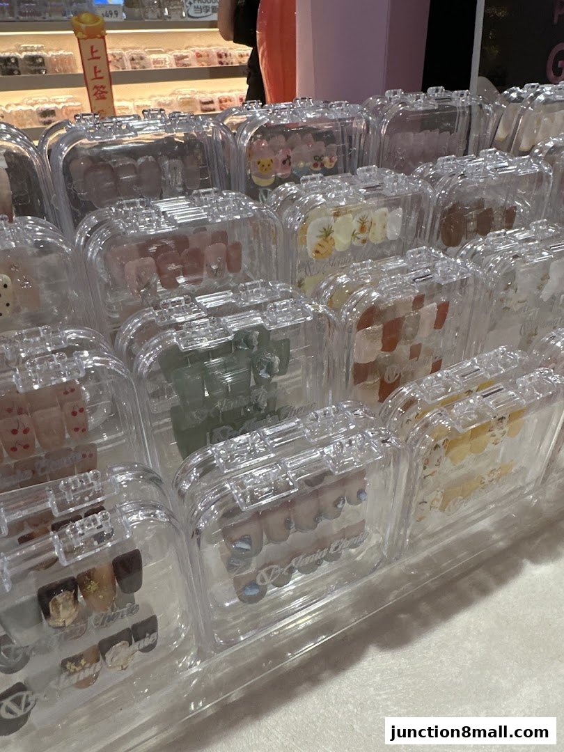 A display of various press-on nail sets in clear protective cases.