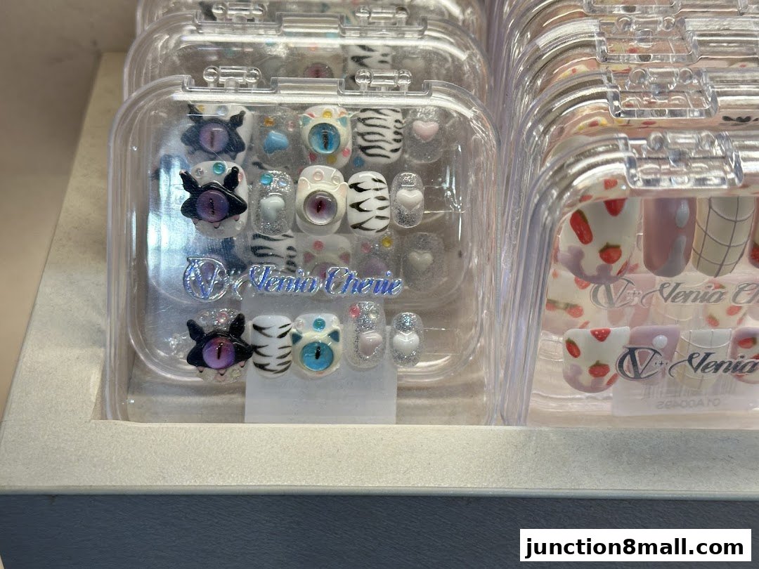 Close-up of display cases filled with various press-on nail designs, featuring unique eye and strawberry motifs.