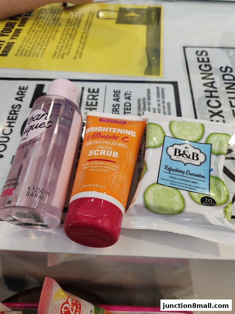 A collection of beauty products including a facial mist, facial scrub, and cucumber facial wipes.