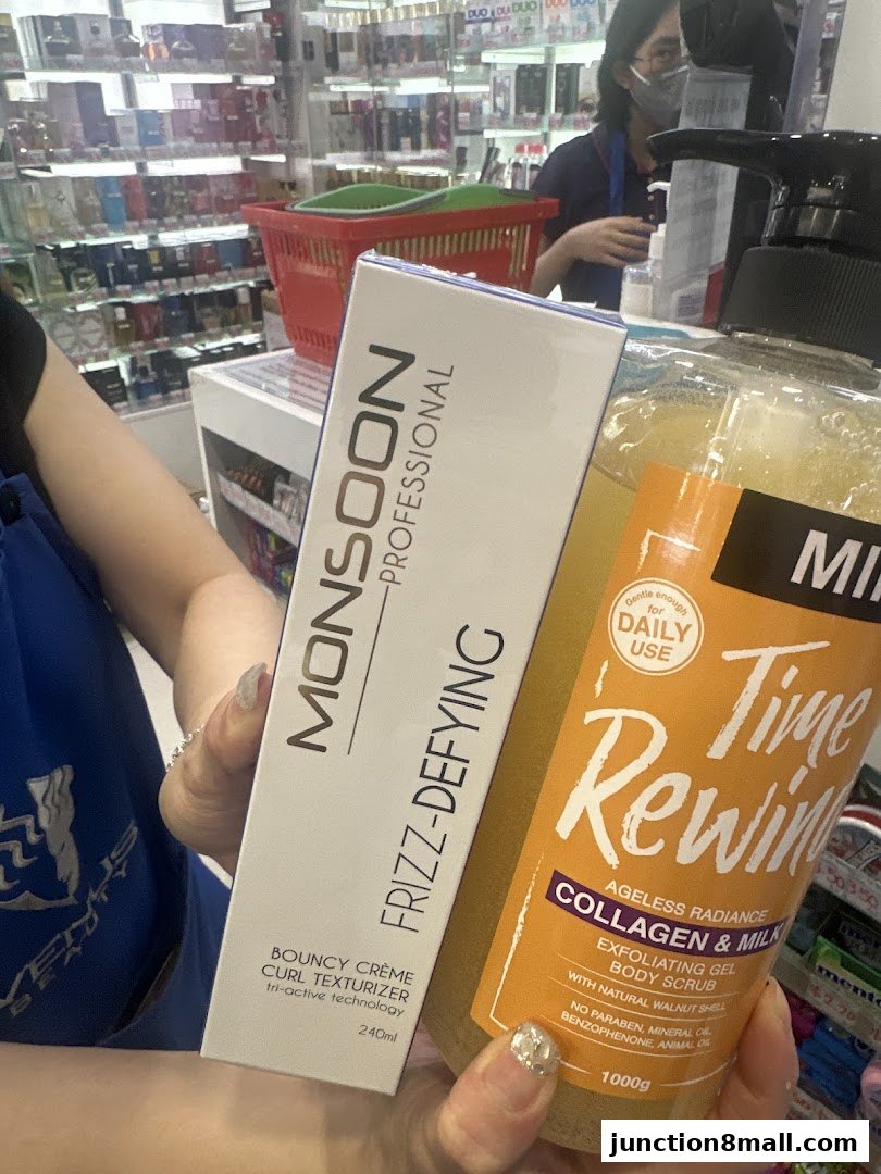 A person holds Monsoon Professional Frizz-Defying Bouncy Creme and Time Rewind Collagen & Milk Body Scrub.