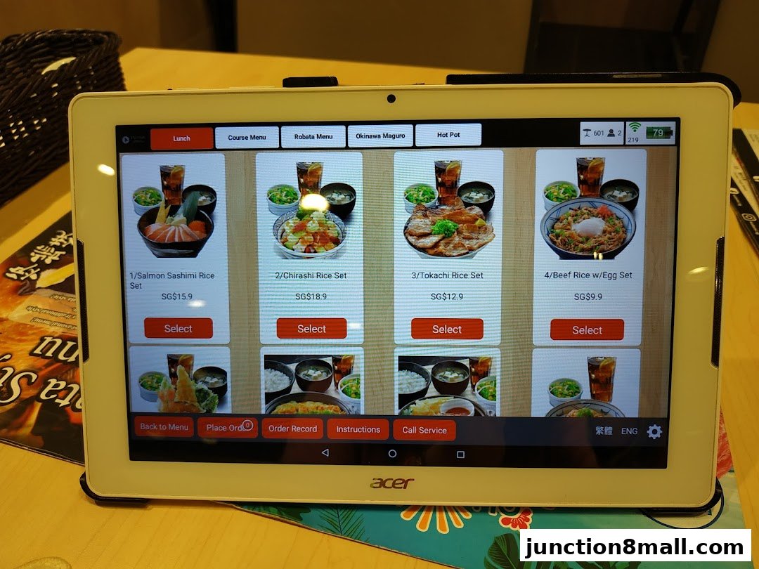 A tablet displays a digital menu with various Japanese lunch sets and prices.