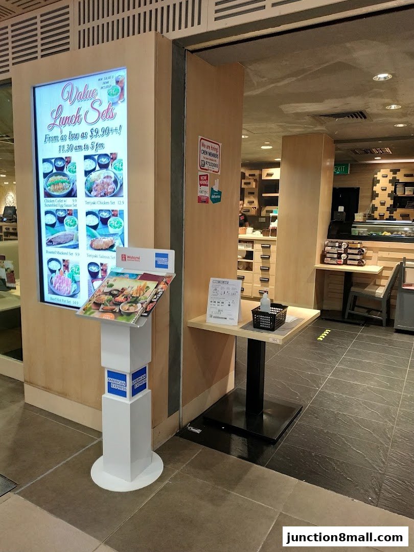 A digital display board and menu stand outside a Japanese restaurant.