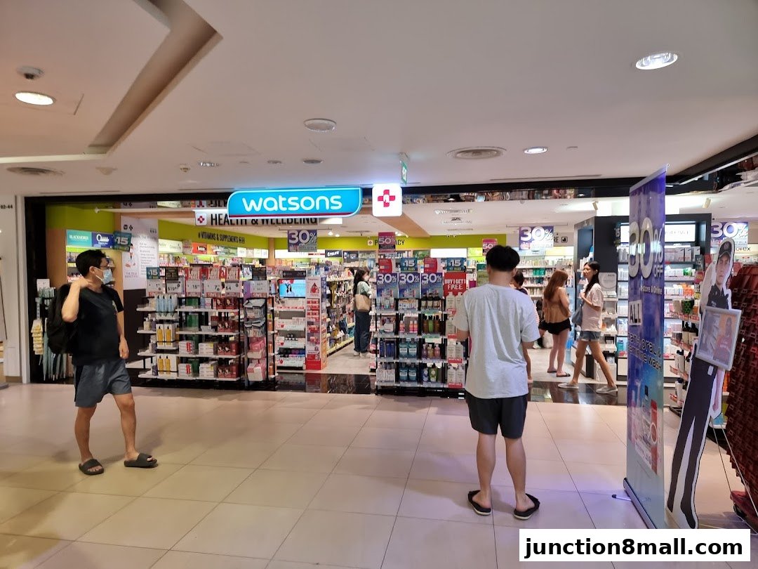People browsing inside a Watsons pharmacy and health store with promotional signs.