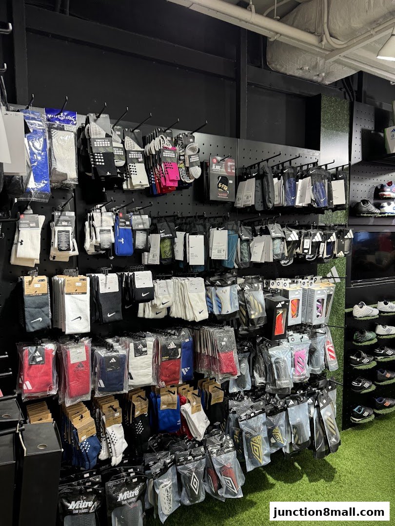 A wall display of athletic socks and shin guards in various colors and brands.