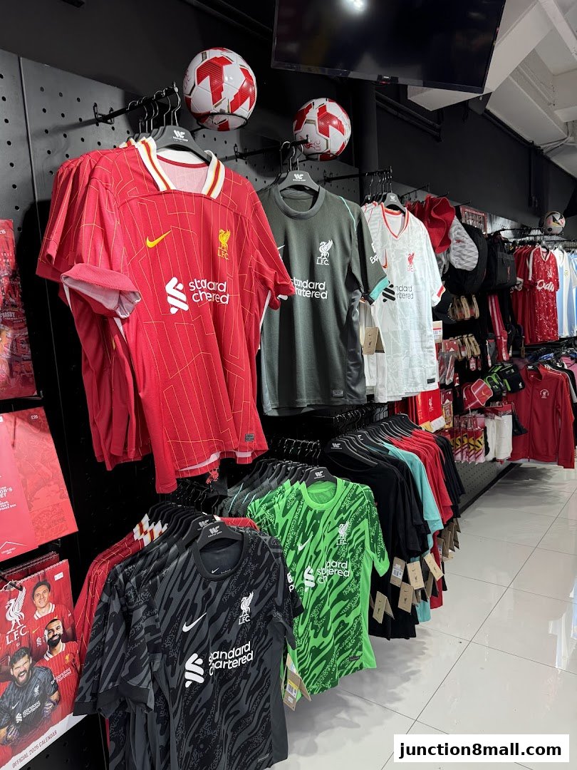A display of football jerseys and soccer balls in a retail store.