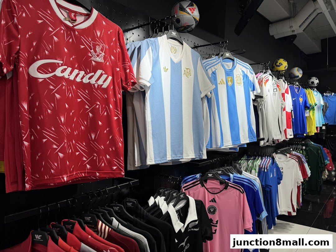 A display of various football jerseys and sports apparel hanging on racks.