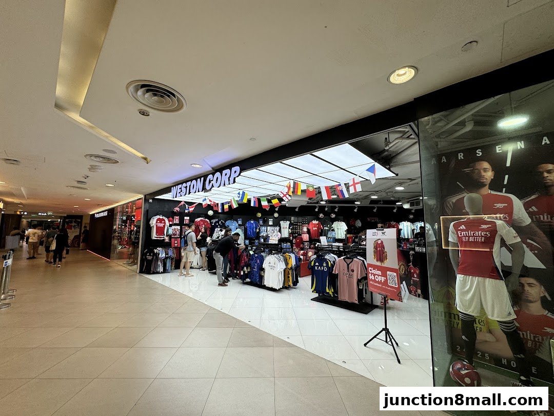 Weston Corp, a sports apparel store, displays jerseys and flags, with a large Arsenal advertisement in the window.