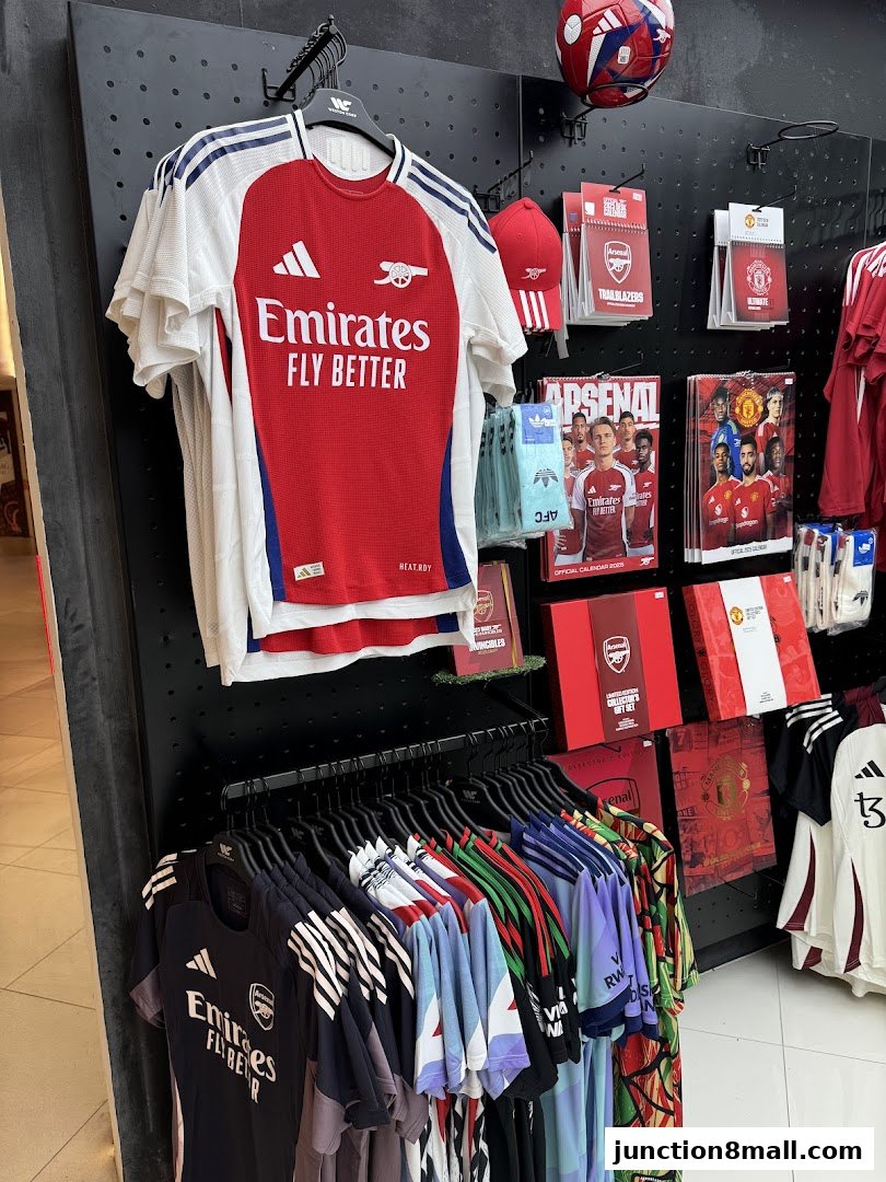 A display of football jerseys, caps, and merchandise from various teams, including Arsenal and Manchester United.