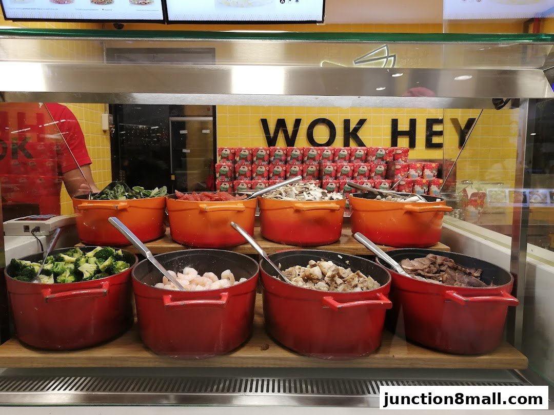 A display of fresh ingredients in pots at Wok Hey, with the restaurant's logo visible.