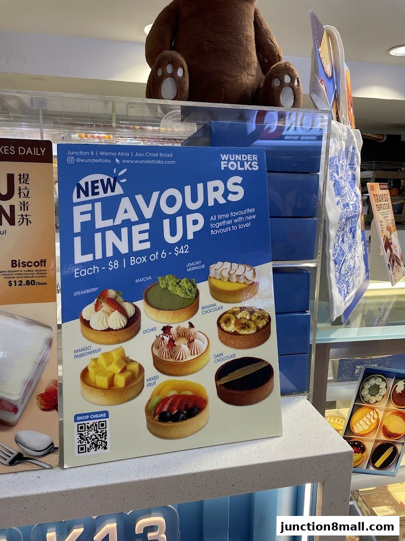 A display board showcasing new tart flavors from Wunderfolks with images and prices.